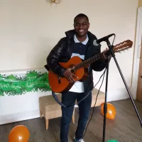 A staff playing guitar for the residents