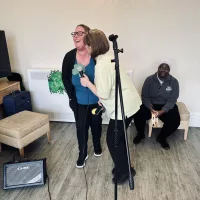 Two staff singing to the residents